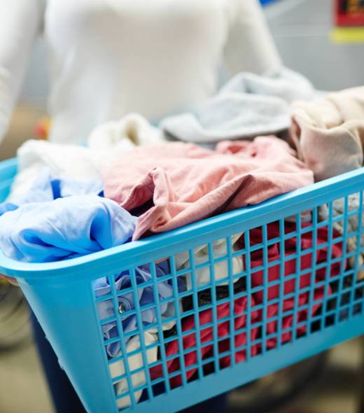 Basket with dirty clothes held by laundress